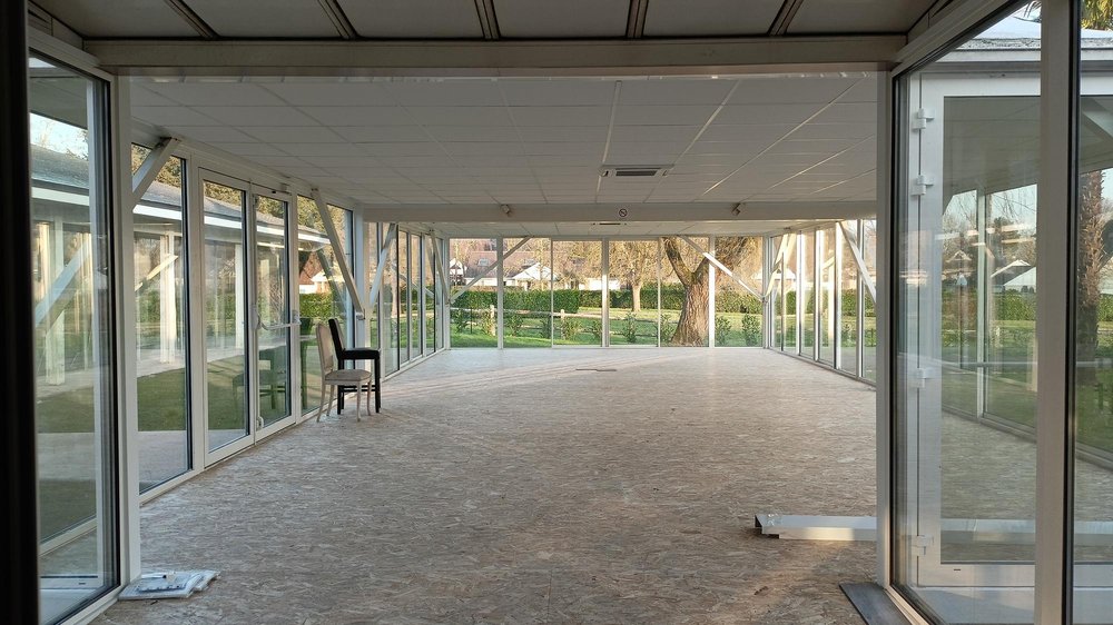 Le même espace après travaux; plafonds neufs, sol refait, parois vitrées